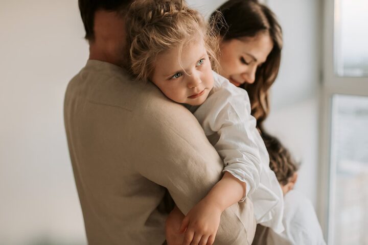 A child in her parents arms experiences a child-focused alternative divorce.