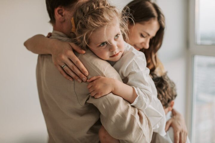 A child in her parents arms experiences a child-focused alternative divorce.